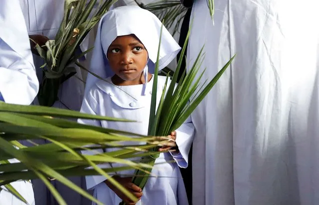 A child holds palm leaves as she attends a Palm Sunday mass at the St. Mary's, Legio Maria of African Church Mission in Makongeni district of Nairobi, Kenya on March 24, 2024. (Photo by Monicah Mwangi/Reuters)