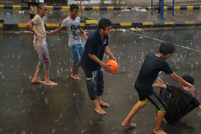 Yemen youths play soccer in the rain on a street in Taiz city, Yemen, Sunday, May 17, 2015. (Photo by Abdulnasser Alseddik/AP Photo)