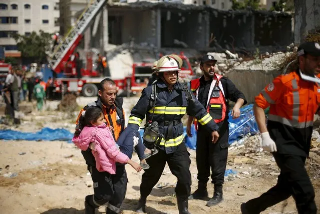 Medics and members of Palestinian Civil Defence reenact a scene simulating the evacuation of a girl during a drill, at a building destroyed during the 2014 war, in Gaza City April 19, 2016. (Photo by Suhaib Salem/Reuters)