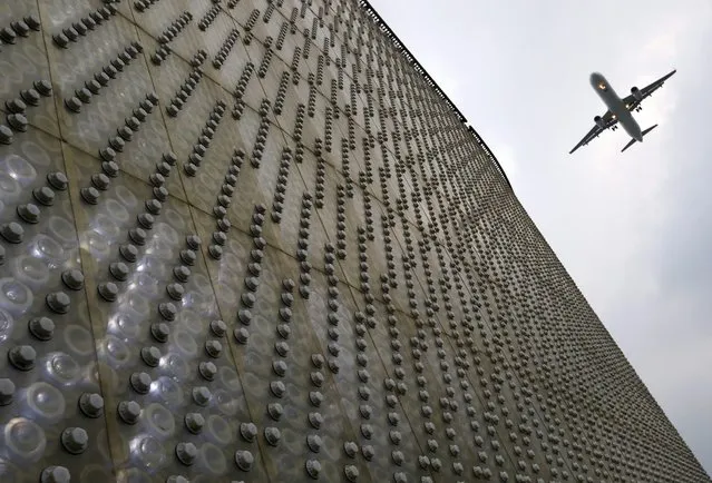 A plane flies past a dome wall made from 1.5 million recyclable PET plastic bottles during the earth day celebration in Taipei, Taiwan, 22 April 2016. Earth Day is celebrated annually on 22 April, to raise awareness and develop a sense of public responsibility pertaining to environmentally-sustainable practices in order to build and maintain a healthy, global ecosystem and maintain a viable planet for future generations. (Photo by Ritchie B. Tongo/EPA)