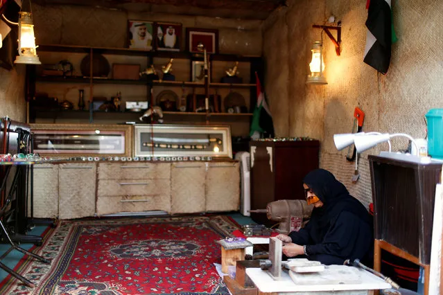 An Emirati woman makes handmade traditional products at the Heritage Village in Dubai, UAE March 13, 2016. The Heritage Village was created in 1997 in Al Shindagha Historical Neighborhood in Dubai, close to the Diving Village, to embrace the heritage events and to display a live image of the old traditional life in UAE. It represents the components of wild, marine, and mountain life, where the visitor can identify closely the old traditional customs of the country and the special characteristics of old houses, handicrafts, patterns, and forms of living. It is owned and managed by Dubai Culture & Arts Authority. (Photo by Ahmed Jadallah/Reuters)