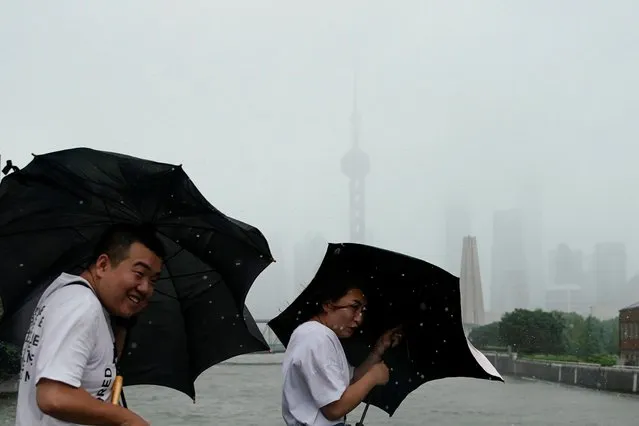 People walk in the rainstorm as typhoon Lekima approaches in Shanghai, China on August 10, 2019. (Photo by Aly Song/Reuters)