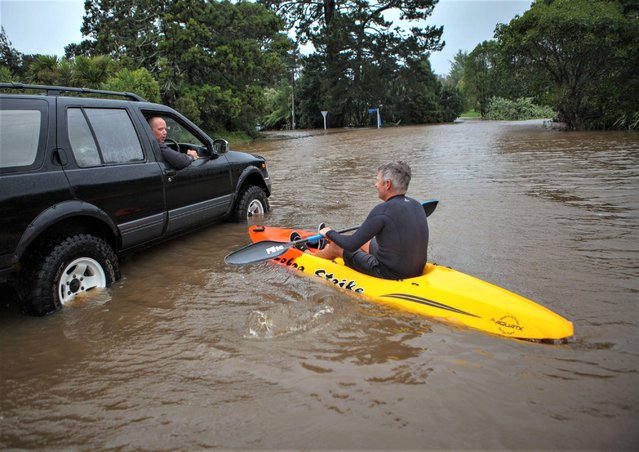 A man kayaks across a flooded street in Auckland, New Zealand on February 14, 2023. The New Zealand government declared a National State of Emergency on Tuesday before Cyclone Gabrielle unleashes its full fury. This is only the third time in New Zealand history that a national state of emergency has been declared. (Photo by Zhao Gang/Xinhua/Alamy Live News)