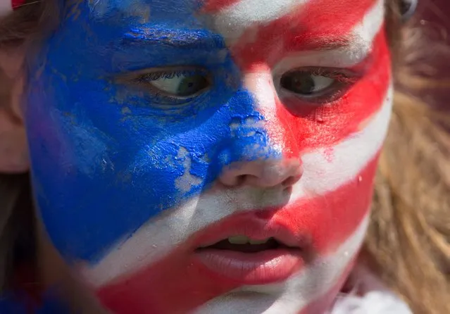 A young United States fan looks at the face paint on her nose as she waits for the U.S. and Japan to play in the  FIFA Women's World Cup soccer championship in Vancouver, British Columbia, Canada, on Sunday, July 5, 2015. (Photo by Darryl Dyck/The Canadian Press via AP Photo)