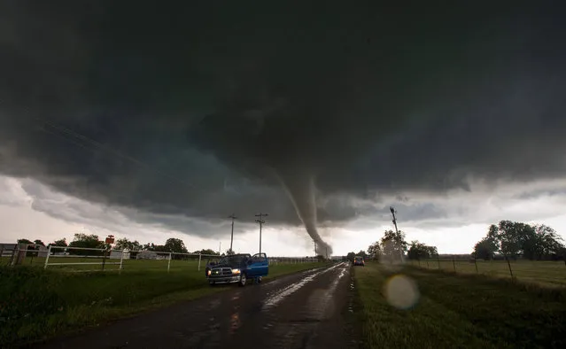 Vehicles stop on the side of a road as a tornado rips through a residential area after touching down south of Wynnewood, Oklahoma on May 09, 2016. The tornado touched down quickly and destroyed an unknown number of structures before a series of other twisters riddled the area. One person is confirmed dead. (Photo by Josh Edelson/AFP Photo)