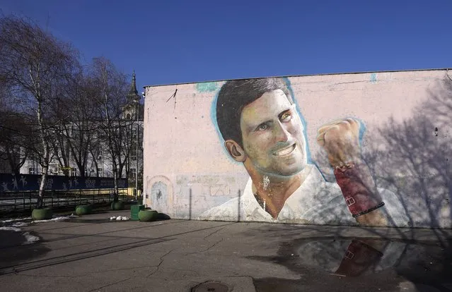 A mural depicting Serbian tennis player Novak Djokovic on a wall in Belgrade, Serbia, Sunday, January 16, 2022. Novak Djokovic was preparing to leave Australia on Sunday evening after losing his final bid to avoid deportation and play in the Australian Open despite being unvaccinated for COVID-19. A court earlier unanimously dismissed the No. 1-ranked tennis player's challenge to cancel his visa. (Photo by Darko Vojinovic/AP Photo)