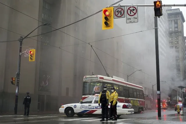 Police block the street as smoke pours into the air following a series of loud blasts were heard in Toronto on Monday, May 1, 2017. (Photo by Graeme Roy/The Canadian Press via AP Photo)