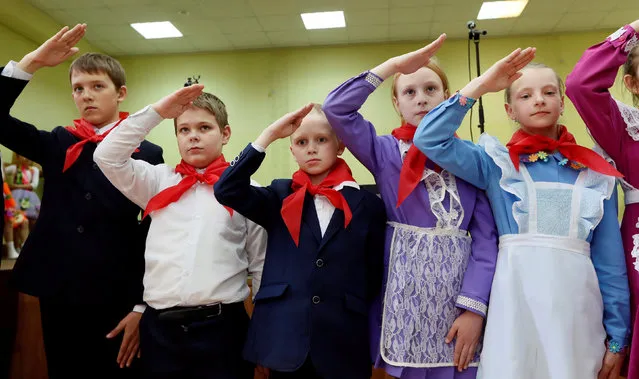Children, wearing red neckerchiefs, a symbol of the Young Pioneer Organisation, salute during a ceremony for the inauguration of new members on the day of its anniversary at school-lyceum number 12 in the Siberian city of Krasnoyarsk, Russia, May 19, 2016. (Photo by Ilya Naymushin/Reuters)