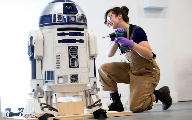 Museum technician Jessie Giovane Staniland checks the original R2-D2, used in the 1977 “Star Wars” film, as it arrives at V&A Dundee in Scotland on October 23, 2019, where it will be the centrepiece of the forthcoming Hello, Robot exhibition. (Photo by Jane Barlow/PA Images via Getty Images)