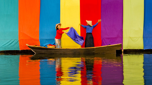 Freshly dyed fabrics are hung out to dry along the water’s edge by workers in Kampung Budaya Sindangbarang, Indonesia in the last decade of June 2024. (Photo by Riza Amrullah/Solent News)