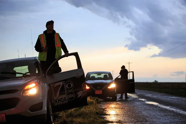 (L to R) Meteorologist Nicholas Stewart and Robin Duspara, who traveled to the U.S. from Prague and runs the Czech Thunderstorm Research Association, pull over and hop out of their cars to observe a supercell thunderstorm as it bears down on the area, May 9, 2017 in Lamb County, Texas. (Photo by Drew Angerer/Getty Images)