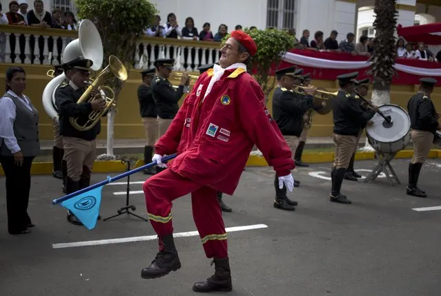 A patient from the Larco Herrera Psychiatric Hospital marches in a firefighter's costume during the hospital's Independence Day parade in Lima, Peru, Wednesday, July 22, 2015. The parade is held on the hospital's campus every year ahead of the Andean nation's official Independence Day celebrations on July 28. (Photo by Martin Mejia/AP Photo)