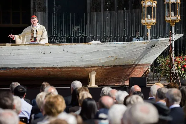 Cardinal and Archbishop Rainer Maria Woelki celebrates a Corpus Christi mass on a refugee boat serving as an altar in Roncalliplatz square in front of the cathedral in Cologne, Germany, 26 May 2016. (Photo by Rolf Vennenbernd/EPA)