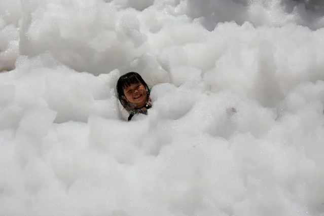 A child plays with foam bubbles during the Love Foam Run race in Hsinchu, Taiwan May 29, 2016. (Photo by Tyrone Siu/Reuters)