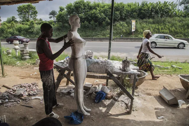 In Ivorian popular culture, Awoulabas are beautiful women with large breasts and, above all, big buttocks. Here: An apprentice polishes a mannequin. Each one usually takes a week to complete. (Photo by Joana Choumali)