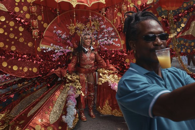 A man takes a selfie with a reveler during the West Indian Day Parade on Monday, September 2, 2024, in the Brooklyn borough of New York. (Photo by Andres Kudacki/AP Photo)