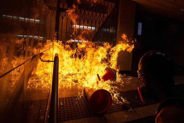 An anti-government protester throws a molotov cocktail towards riot police officers inside the Wan Chai station during a demonstration in Hong Kong, China, September 29, 2019. (Photo by Athit Perawongmetha/Reuters)