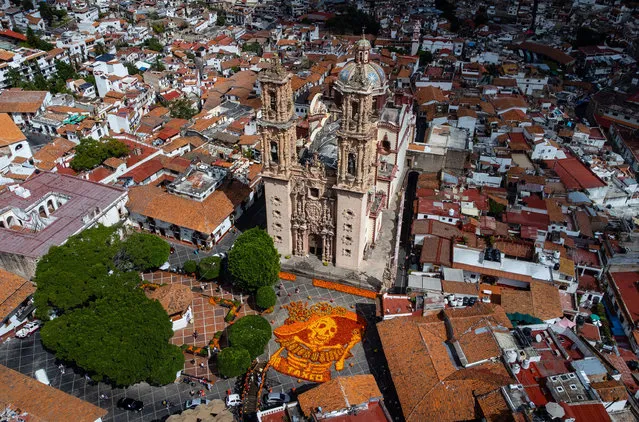 An aerial view of the figure of a Catrina skull made with 18,000 Cempasuchil flowers (Mexican marigold) is on display at the Church of Santa Prisca as part of Day of the Dead celebrations, in Taxco, Mexico on October 27, 2021. (Photo by Daniel Cardenas/Anadolu Agency via Getty Images)