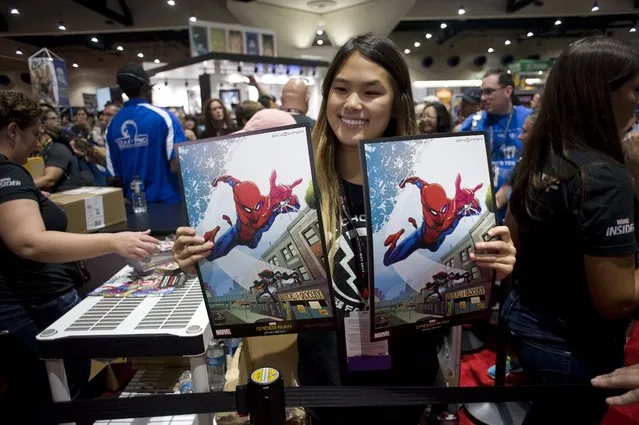 A woman shows free give away memorabilia during the preview night for Comic Con 2017 in San Diego, California, USA, 19 July 2017. (Photo by David Maung/EPA)