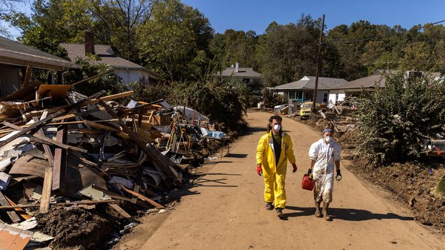 Volunteers walk near debris following the passing of Hurricane Helene, in Swannanoa, North Carolina on October 7, 2024. (Photo by Eduardo Munoz/Reuters)