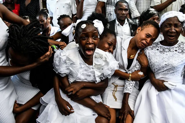 A girl cries during her father's funeral organised by government opposition in Port-au-Prince, Haiti on October 16, 2019. The Haitian opposition on October 9 rejected President Jovenel Moise's appeal for dialogue, as the country's main cities remained paralyzed after more than a month of often violent protests. Over the past year, Haiti has sunk deeper into political crisis as anti-corruption protests demanding Moise's resignation roil the destitute Caribbean nation. (Photo by Chandan Khanna/AFP Photo)