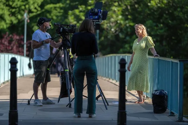 A weather presenter speaks to the camera during a broadcast from St James's Park on June 15, 2022 in London, England. Hot air originating in North Africa and travelling up through Spain may bring temperatures up to 32C to the UK in the coming days. (Photo by Carl Court/Getty Images)