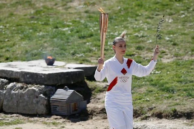 First torchbearer, Greek shooting athlete Anna Korakaki, carries the Olympic flame and the olive branch during the opening of the Olympic flame torch relay for the Tokyo 2020 Summer Olympics in Ancient Olympia,Greece on March 12, 2020. (Photo by Costas Baltas/Reuters)
