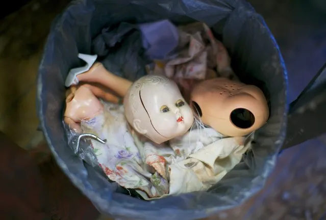 A trash can featuring discarded doll parts including a broken head, torso and limbs is pictured in the workshop of Sydney's Doll Hospital, July 12, 2014. Opened in 1913, Sydney's Doll Hospital has worked on millions of dolls, teddy bears and other toys. (Photo by Jason Reed/Reuters)