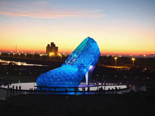 People visit the High-Heeled Shoe Church in Chiayi, western Taiwan, 23 July 2016. The church, costing 7.6 million US dollars, is made with 320 pieces of blue glass and steel frame. It is 17 meter tall, 11 meters wide, 25 meters long, and is certified by the Guineess Word Records as “the largest buliding shaped like a shoe”. The Southwest Coast National Scenic Area Administration built it as one of its four church-themed landmarks, to commemorate gilrs who had their feet amputagted during the 1950s due to blackfoot disease and could not walk down the red carpet in high-heels for their wedding. The glass slipper church was formally opened to public on 22 July. (Photo by David Chang/EPA)