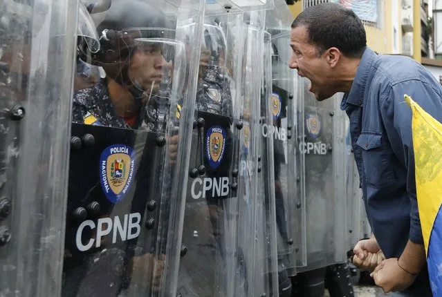 A protester yells at police blocking an opposition march in Caracas, Venezuela, Tuesday, March 10, 2020. U.S.-backed Venezuelan political leader Juan Guaido is leading a march aimed at retaking the National Assembly legislative building, which opposition lawmakers have been blocked from entering. (Photo by Ariana Cubillos/AP Photo)