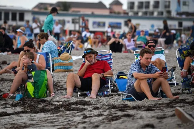 Beachgoers wait for the launch of the Artemis I unmanned lunar rocket, in Cocoa Beach, Florida, on August 29, 2022. NASA called off the test flight on Monday of its largest-ever Moon rocket because of a temperature issue with one of the four giant engines. (Photo by Marco Bello/AFP Photo)