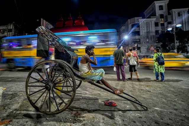 A street rickshaw puller seen sitting along the main road while waiting for customers in Kolkata, India on August 28, 2022. (Photo by Avishek Das/SOPA Images/Rex Features/Shutterstock)