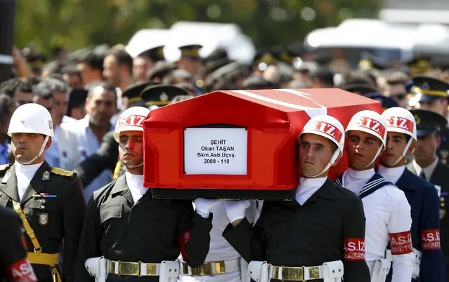 Soldiers carry the flag-draped coffin of Sergeant Okan Tasan, one of the soldiers killed during an attack on a military convoy and clashes on Sunday in the mountainous Daglica area of Hakkari province, at Kocatepe Mosque in Ankara, Turkey, September 10, 2015. (Photo by Umit Bektas/Reuters)