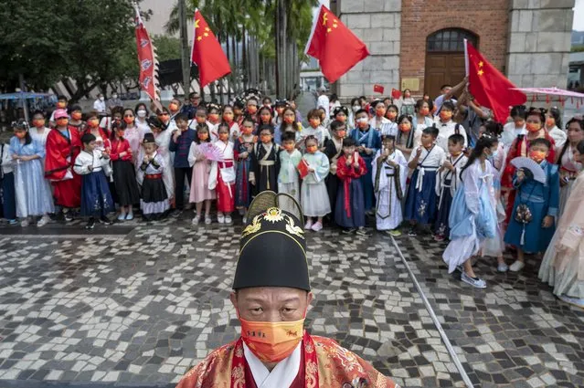 People dressed in Han dynasty costumes hold Chinese flags during China's National Day in Hong Kong, China, 01 October 2022. (Photo by Miguel Candela/EPA/EFE)