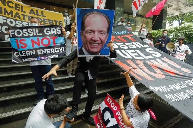 Protesters against fossil fuels display an image of World Bank Group President David Malpass during a rally outside a building housing the World Bank country office in Taguig City, Metro Manila, Philippines 14 October 2022. Members of an environmental protection advocacy group rallied outside the World Bank country office to call on the international institution to resist funding fossil fuel projects and cancel the debt incurred by developing countries due to fossil fuel projects. (Photo by Rolex dela Peña/EPA/EFE)