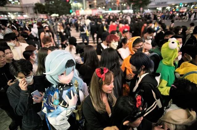People in costumes walk through the famed scramble intersection of Tokyo's Shibuya entertainment district during Halloween festivities, Monday, October 31, 2022. (Photo by Hiro Komae/AP Photo)