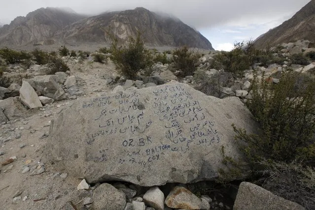 The names of the porters and members of a recent K2 trekking tour are written on a glacial stone along the K2 base camp trek near Korophong in the Karakoram mountain range in Pakistan September 11, 2014. (Photo by Wolfgang Rattay/Reuters)