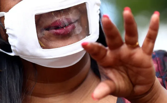 Director of Empowering Deaf Society Mangai Sutharsan uses sign language to communicate whilst wearing a partially transparent mask, following the coronavirus disease (COVID-19) outbreak in Ilford, London, Britain, July 29, 2020. (Photo by Hannah McKay/Reuters)