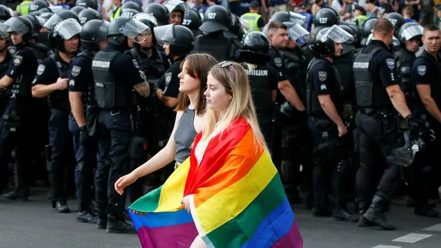 Police officers guard participants of the Equality March, organized by the LGBT community, in Kiev, Ukraine on June 23, 2019. (Photo by Gleb Garanich/Reuters)