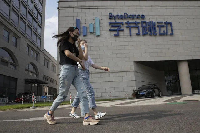 Women wearing masks to prevent the spread of the coronavirus chat as they pass by the ByteDance headquarters in Beijing, China on Friday, August 7, 2020. President Donald Trump on Thursday ordered a sweeping but unspecified ban on dealings with the Chinese owners of consumer apps TikTok and WeChat, although it remains unclear if he has the legal authority to actually ban the apps from the U.S. TikTok is owned by Chinese company ByteDance. (Photo by Ng Han Guan/AP Photo)