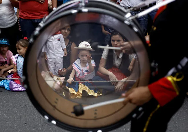 Children look at students taking part in a parade commemorating Costa Rica's Independence Day in San Jose, Costa Rica, September 15, 2016. (Photo by Juan Carlos Ulate/Reuters)