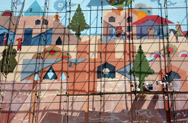 Artists work on a scaffolding on a mural on a building's facade in Tehran, Iran, 02 April 2025. (Photo by Abedin Taherkenareh/EPA)