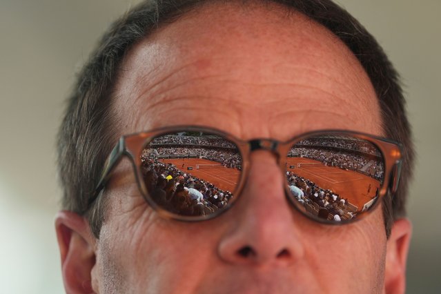 The court Simonne-Mathieu is reflected in the sunglasses of Jeff Amsel as he watches the first round match of the French Tennis Open between Taylor Fritz of the United States, and Germany's Daniel Altmaier, at the Roland-Garros stadium, in Paris, Monday, May 26, 2025. (Photo by Lindsey Wasson/AP Photo)