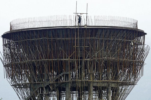 A labourer works at the construction site of an elevated water tank in Ajmer on July 17, 2025. (Photo by Himanshu Sharma/AFP Photo)
