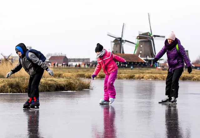 Ice skaters skate on natural ice at the Dutch “Zaanse Schans” near Zaandam on March 1, 2018. Heavy snowfall and deadly blizzards lashed Europe, forcing airports to cancel or delay flights around the continent, as a deep freeze gripped countries from the far north to the Mediterranean beaches in the south. (Photo by Remko de Waal/AFP Photo/ANP)