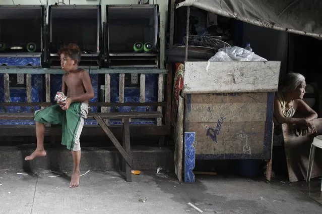 Residents watch as policemen, not shown, patrol their community during an operation as part of the continuing “War on Drugs” campaign of Philippine President Rodrigo Duterte in Manila, Philippines on Thursday, October 6, 2016. An independent poll released Thursday showed that more than three-quarters of Filipinos are satisfied with President Duterte, even though he is under fire internationally for his deadly crackdown on suspected drug dealers and users. (Photo by Aaron Favila/AP Photo)