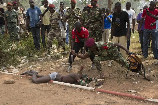 A Central African Army (FACA) soldier stabs the corpse of a man, who was killed after he was accused of joining the ousted Seleka fighters, in the capital Bangui, in this February 5, 2014 file photo. (Photo by Siegfried Modola/Reuters)