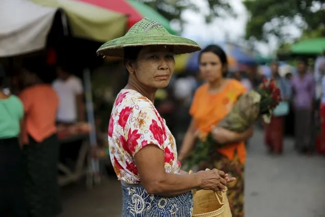 A woman reacts while walking in a market in Mandalay, Myanmar, October 7, 2015. (Photo by Jorge Silva/Reuters)