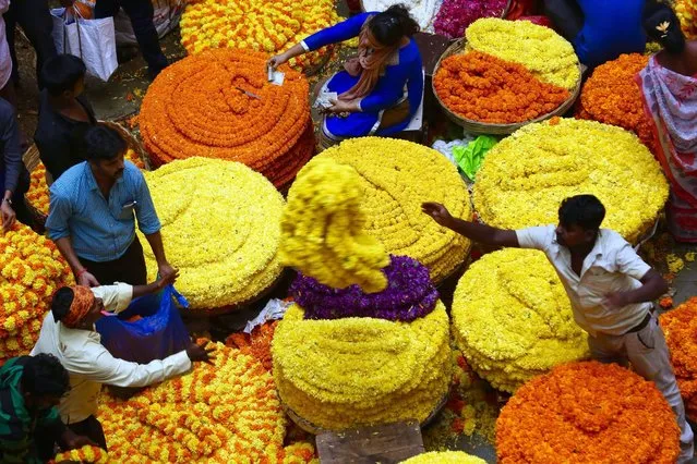 Visitors buy flowers at a flower market on the eve of Hindu goddess Durga Puja festival in Bangalore, India, 10 October 2016. The nine-day Hindu festival celebrates the killing of a demon king by the Goddess Durga representing the victory of good over evil and ends with colourful celebrations all over the country. Navratri festival runs from 03 to 11 October. (Photo by Jagadeesh N.V./EPA)