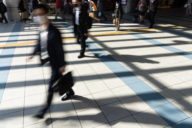 Pedestrians walk across a concourse at Shinagawa station in Tokyo, Japan on March 15, 2023. The government began leaving the decision of wearing masks up to individuals on 13 March. (Photo by AFLO/Rex Features/Shutterstock)